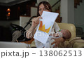 Working mother holding a sleeping baby having a video conference call at home 138062513
