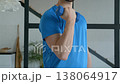 Close-up of active sporty muscular build man practicing weight training, performing dumbbell biceps curl, strengthening upper arm muscles while exercising in domestic room. 138064917