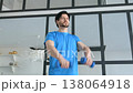 Active sporty muscular build man practicing dumbbell front raise to lateral raise exercise, strengthening middle deltoids and anterior deltoids of shoulders indoors. 138064918