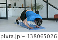 Determined sporty fit man performing pike push up exercise, strengthening shoulder muscles and improving core stability while working out in domestic room. 138065026