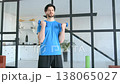 Motivated determined sporty muscular build man practicing dumbbell biceps curl workout, building strength in upper arm muscles and boosting athletic performance during indoors sports training . 138065027