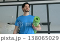 Portrait of active motivated handsome sporty fit man holding rolled up exercise mat, looking with cheerful smile, expressing confidence and positivity at home. 138065029