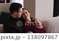 Cozy couple shares a tender moment on the couch in a warm setting 138097867