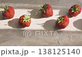 Fresh whole strawberries on marble board with harsh sunlight shadows. Organic red berries arranged on stone surface for healthy summer snack or cooking preparation. 138125140