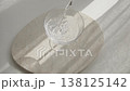 Fresh sparkling water pouring into elegant crystal glass on marble tray. Pure liquid refreshment with bubbles on stone surface in bright natural sunlight with shadows. 138125142
