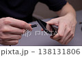 Hands holding black smartphone and usb-c cable poised to plug into port, symbolizing charging, data transfer, connectivity and everyday digital convenience for modern devices, close-up, slow motion. 138131806