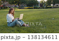 Busy business woman female student girl businesswoman freelancer typing on laptop work remote on Internet in city outdoors sitting on grass. 138134611
