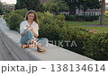 Attractive woman making notes in notebook sitting outdoor alone closeup. 138134614