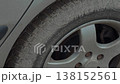 Dirty car tire covered in sand and dirt high angle 138152561