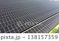 Slow aerial tracking shot over diagonal solar panel rows 138157359