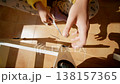 Young Lady Assembling Furniture Smoothly. Woman Tightening Screw On Wooden Chair In Sunlit Cozy Room 138157365