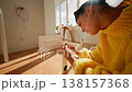 Young Lady Assembling Furniture Smoothly. Woman Tightening Screw On Wooden Chair In Sunlit Cozy Room 138157368