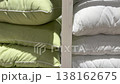 Rows of new green and white soft pillows stacked neatly on wooden shelves in a retail store, with sunlight and shadows moving across them, suggesting the passage of time 138162675