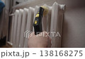 Hand using steamer with brush attachment for thorough cleaning of intricate radiator fins, ensuring household hygiene and effective maintenance of heating systems at home, close-up, slow motion. 138168275