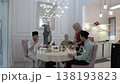 Family dinner at kitchen table with headscarves, warm hosting 138193823