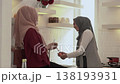 Two women exchange conversation while cooking in kitchen 138193931