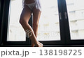 Legs of Sexy Female Model Standing by Window in White Lingerie 138198725