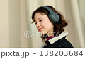 Side portrait of teen girl in warm denim jacket with wireless headphones, concentrating on audio lesson or podcast, concept online education and remote learning for teenagers. 138203684