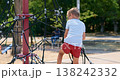 Young boy climbing rope structure at outdoor playground on sunny day 138242332