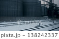 Winter Train Journey Past Industrial Silos and Snowy Landscape 138242337