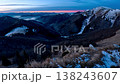 Time lapse of vibrant dawn over mountains with sunlight illuminating snowy and grassy slopes 138243607