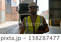 Worker with tablet walk at cargo storage place. Truck follow him. 138287477