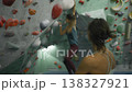 slow motion footage of female rock climber practicing on climbing wall, slow motion shot of woman climbing, extreme sports, bouldering practice . High quality 4k footage 138327921
