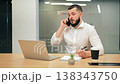 Focused Professional Engaged in Phone Conversation at Modern Office 138343750