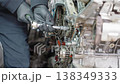 Close-up shot of a skilled mechanic tightening a bolt on an engine. Ideal for car service, repair tutorials, maintenance training, engineering content and technical documentation. 138349333