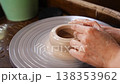 Learn to shape clay on a pottery wheel in a workshop setting 138353962