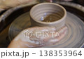 Creating pottery on the wheel in a workshop setting 138353964