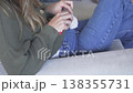 Woman working on a crochet project while sitting on a sofa at home. Close-up lifestyle scene 138355731