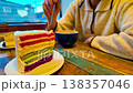 Woman eats fresh baked homemade Rainbow cake with coffee 138357046