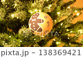 Christmas ball for decorating a New Year tree or interior. a beautiful ball on the background of a Christmas tree with a glowing garland. gingerbread man smiling on New Year's Eve 138369421