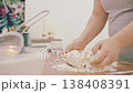 The hands of a female cook knead a lump of dough on a wooden table with white wheat flour. High quality 4k footage 138408391