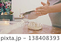 A female cook kneads a lump of white wheat flour dough on a wooden table. High-quality 4K video. 138408393