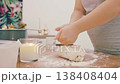 A female cook kneads a lump of white wheat flour dough on a wooden table. High-quality 4K video. 138408404