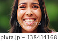 Close-up of a happy young woman with tears of joy, laughing heartily in an outdoor setting. 138414168