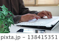 Image of a man working remotely in a brightly lit room (focus on the foreground, face not visible) - Smartphone 138415351