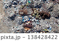 View from sky drone footage showing scattered construction debris and plastic waste at an open dump site. 138428422