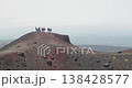 Group of hikers standing on a hill overlooking the valley near Etna Volcano, 4k 138428577