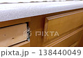 The video shows a hand pulling open a wooden kitchen drawer, revealing an empty interior lined with a light patterned drawer liner. The surrounding cabinetry and countertop create a warm home kitchen 138440049