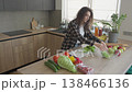 Woman Tearing Fresh Green Lettuce Leaves Into Bowl In Modern Kitchen 138466136