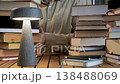 Man holding stack of books on desk with lamp education concept 138488069