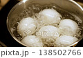 Witness the process of boiling eggs in a pot as the water bubbles vigorously, showcasing preparation for a nutritious breakfast. 138502766