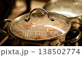 A pot simmers on the stovetop, steam rising from the bubbling stew filled with vegetables and meat, showcasing a warm culinary experience in the kitchen. 138502774