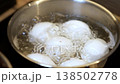 Water bubbles vigorously as eggs cook in a pot on the stove, demonstrating the technique for achieving the ideal hard or soft boiled eggs. 138502778