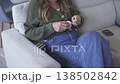 Casual Scene Of Woman Leisurely Knitting Sweater With Natural Light In Comfortable Home Environment 138502842