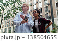 Young man is showing something to his female friend on his smartphone, she seems unconvinced by his explanation as he becomes increasingly animated 138504655