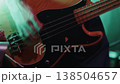 Close up of a musician's hands skillfully playing a bass guitar on stage during a concert. Dark clothing enhances the focus on the performance and the energy of the live event 138504657